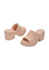 Beżowe mule na platformie wykonane z gładkiego materiału, z otwartym noskiem i wyprofilowanym obcasem o lekko zaokrąglonym kształcie oraz teksturowanej podstawie.