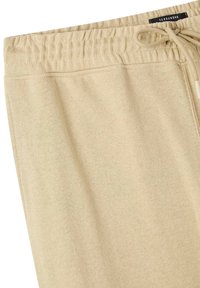 Pantaloni della tuta beige realizzati in tessuto morbido, dotati di una vita elastica con coulisse e vestibilità rilassata per il massimo comfort.