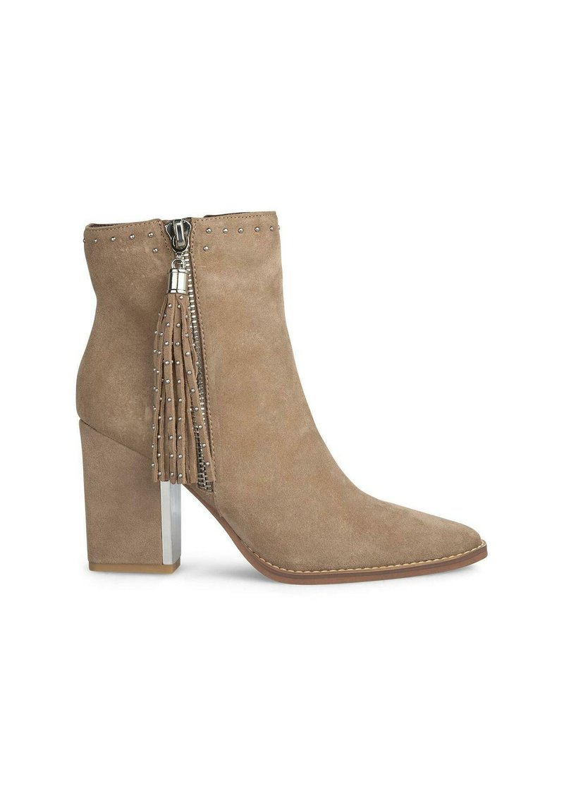 Botín de ante beige hasta el tobillo con punta afilada, cremallera de hardware plateado, adorno de borlas y tacón bloque transparente. Presenta detalles de tachuelas en la parte superior.