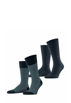Dunkelblaue einfarbige Socken und gemusterte teal-farbene Socken mit einem dunkelblauen Bündchen. Die Socken haben eine glatte Textur und sind in unterschiedlichen Höhen.