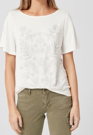 Hvid t-shirt med korte ærmer med et fint gråt blomsterprint, løs pasform og rund halsudskæring, kombineret med olivengrønne bukser.