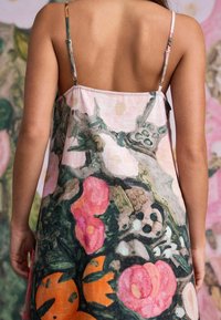 Voľné, bezrukávové šaty s kvetinovým vzorom v ružovej, oranžovej a zelenej farbe. Vyrobené z ľahkej tkaniny, s nastaviteľnými ramienkami a uvoľneným strihom.