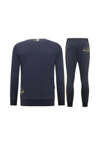 Marineblauwe sweatshirt en bijpassende broek van ribstof. De sweatshirt heeft een ronde halslijn en gouden letterdetails aan de onderkant.