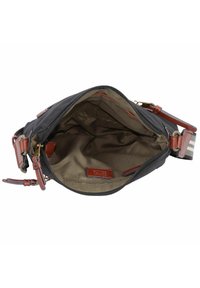 Schwarze Stoff-Umhängetasche mit braunen Lederakzenten, Reißverschluss und einem ungefütterten Innenraum, der ein kleines Logo-Patch und eine beige Fütterung aufweist.