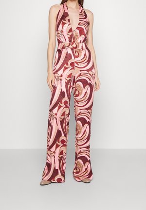 Halter-olkaiminen haalari, jossa syvä V-pääntie ja pyörteilevä vaaleanpunaisen, punaisen ja ruskean kuvio; levenevät lahkeet ja istuva vyötärö.