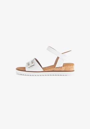 White wedge sandals with a cork heel, adjustable strap, and silver accent. Features a textured footbed and zigzag sole for traction.