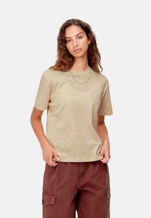 Camiseta de algodón beige con mangas cortas, escote redondo y un ajuste holgado, combinada con pantalones cargo marrones que cuentan con bolsillos laterales.
