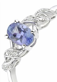 hopeasormus, jossa on soikea purppuranvärinen kivilohkare, ristiin liittyvä muotoilu, jota korostavat pienet kirkkaat kivet ympäri rengasta lisäämään yksityiskohtia.