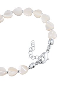 Hjärformad pärlarmband gjort av blekt, iriserande material med silverfärgade metalldetaljer och stängning med hummerklämma. Justerbar kedjedetalj.