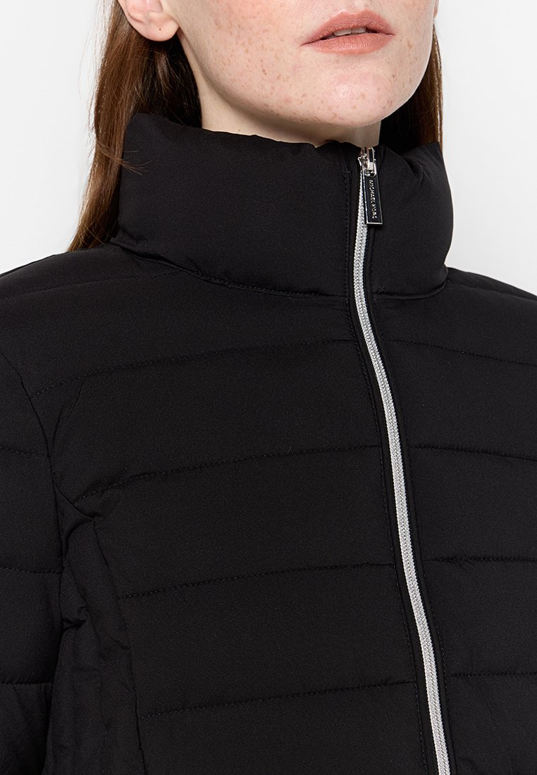 Giacca a vento nera con colletto alto, dotata di zipper argentata e texture a trapunta orizzontale. Finitura in tessuto liscia.