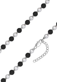 Zwart-witte ketting met afwisselend matte zwarte en glanzende witte parels, voorzien van een zilveren sluiting en een verstelbare ketting.