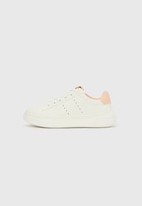 Hvit lavtopp sneaker med ferskenfarget hælstropp, snøring, perforerte detaljer på siden, og tykk gummisåle på ensfarget bakgrunn.