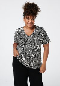 Zwart-witte T-shirt met korte mouwen en V-hals, featuring een bloemen- en geometrisch patroon, met een ontspannen pasvorm en een zachte textuur.