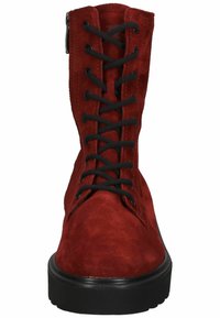 Bottines en suède rouge avec lacets noirs, dotées d'un bout rond et d'une semelle en caoutchouc noire, fermeture éclair sur le côté.