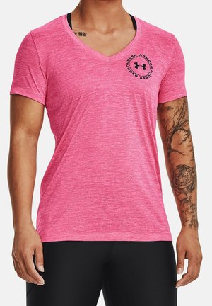 Homme portant un t-shirt rose Under Armour à col en V et manches courtes, avec un pantalon noir, et un tatouage de tigre sur le bras droit.