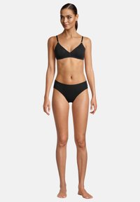 Sort bralette med tynde stropper og matchende sorte bikini-lignende bind. Glat stof med minimal detaljer og et moderne snit.