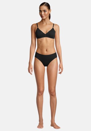 Schwarzer Bralette mit dünnen Trägern und passendem schwarzen Bikinihöschen. Glattes Material mit minimaler Details und einem modernen Schnitt.