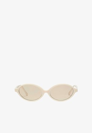 Occhiali da sole ovali color crema con lenti leggermente beige e astine sottili e curve su sfondo bianco.
