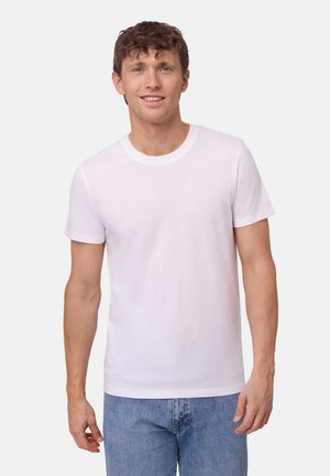 Hvid bomulds T-shirt med rund hals, korte ærmer og en afslappet pasform, parret med lyseblå denim jeans. Minimalistisk design, uden mønstre.