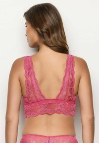 Lace bralette in felroze, met een geschulpte rand, een bloemenpatroon en brede kantenschoen. Het ontwerp aan de achterkant is een lage scoopstijl.