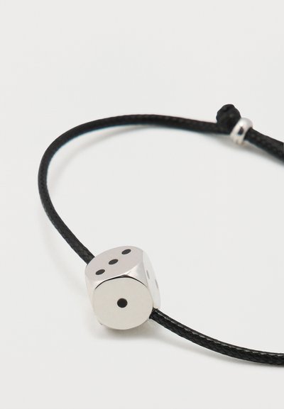 Silver dice-shaped charm on a black braided cord, featuring black dots on two sides and a polished finish. Adjustable size.