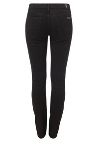 Jeans slim fit negros vistos desde atrás con dos bolsillos, presillas para el cinturón y un sutil detalle de costura en los bolsillos.