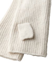 Hvid uldsjaal med ribbet tekstur og et lille firkantet mærke. Blødt materiale og minimalistisk design.