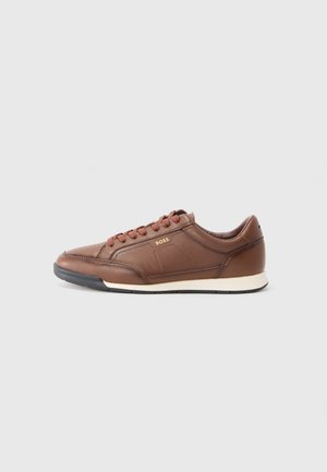 Braune Leder-Sneaker mit runder Zehenpartie, Schnürverschluss, dezentem Nähen und strukturiertem weißen Sohlen. Minimale Markenkennzeichnung an der Seite.