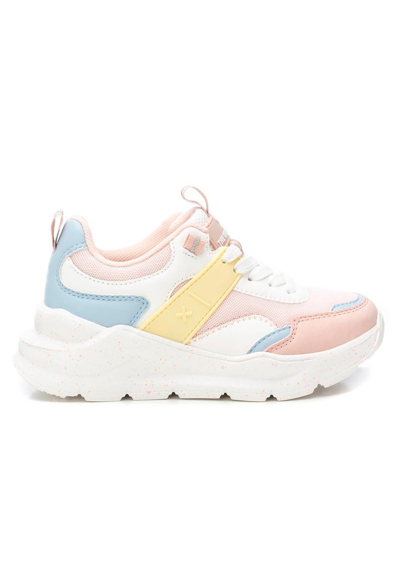 Zapatilla blanca, rosa y azul con suela texturizada, que presenta una cinta de acento amarilla y material de malla. Punta redondeada y diseño de cordones.