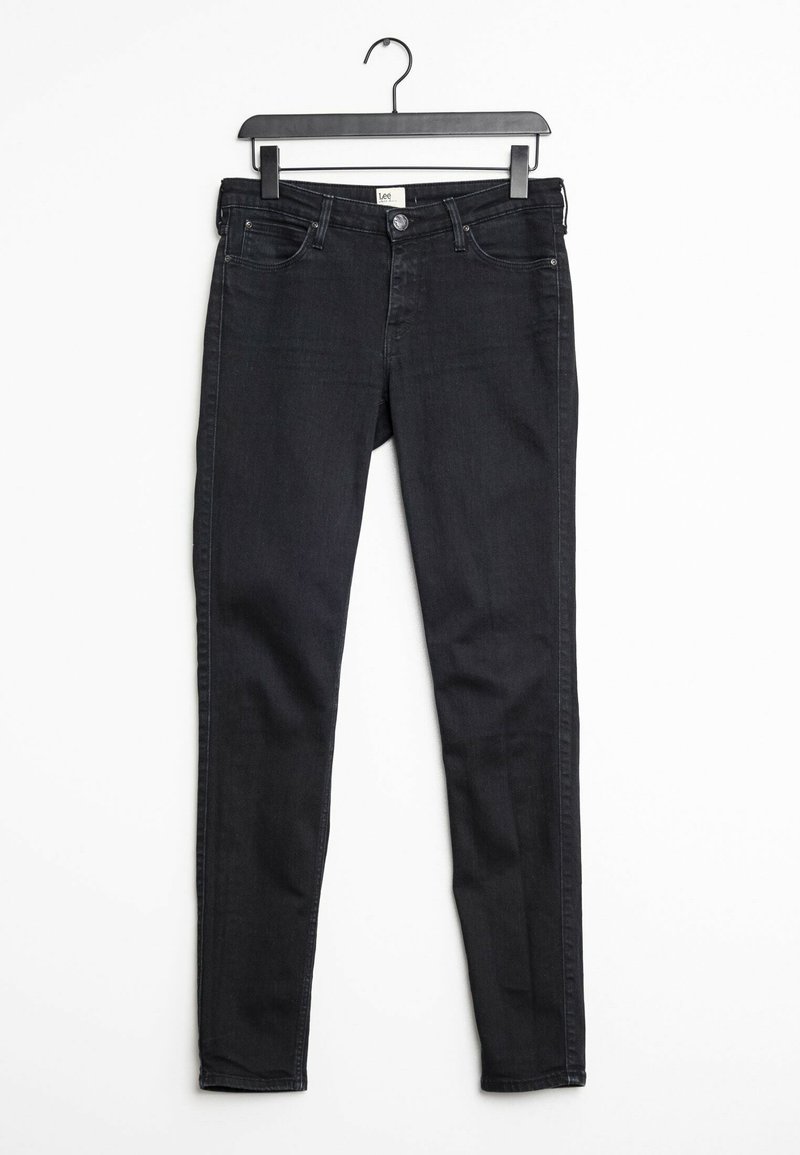 Svarta slim-fit jeans tillverkade av denim, med standard femfickorsdesign, knäppning och bälteshällor, hängande på en svart galge.