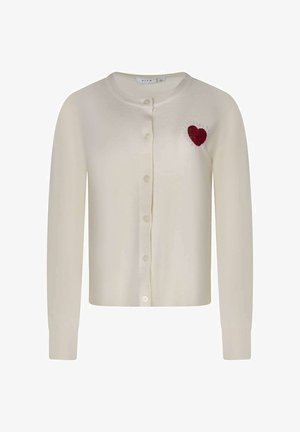 Cardigan crème boutonné à manches longues avec un patch cœur rouge sur la partie supérieure gauche de la poitrine.