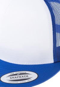 Plava i bijela snapback kapica s čvrstim prednjim panelom i mrežastim stranama. Oznaka na brimu prikazuje "The Classics" i "Yupoong od 1974."