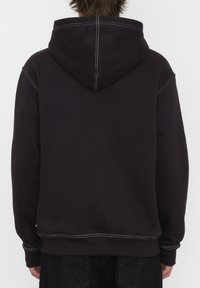 Sweat-shirt à capuche noire avec des coutures blanches contrastantes. A une coupe décontractée et des poignets et un ourlet côtelés. Fabriqué en tissu polaire doux.