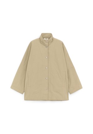 Smėlio spalvos laisvo kirpimo švarkas su aukštu apykakliu, ilgomis plačiomis rankovėmis, priekinėmis spaudėmis ir šoninėmis kišenėmis su plyšiu, išdėliotas horizontalioje baltoje fone.