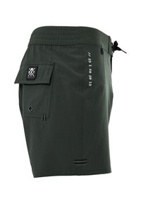 Shorts verts en tissu léger, avec une taille élastique, une poche latérale avec rabat, et des détails imprimés sur le côté.