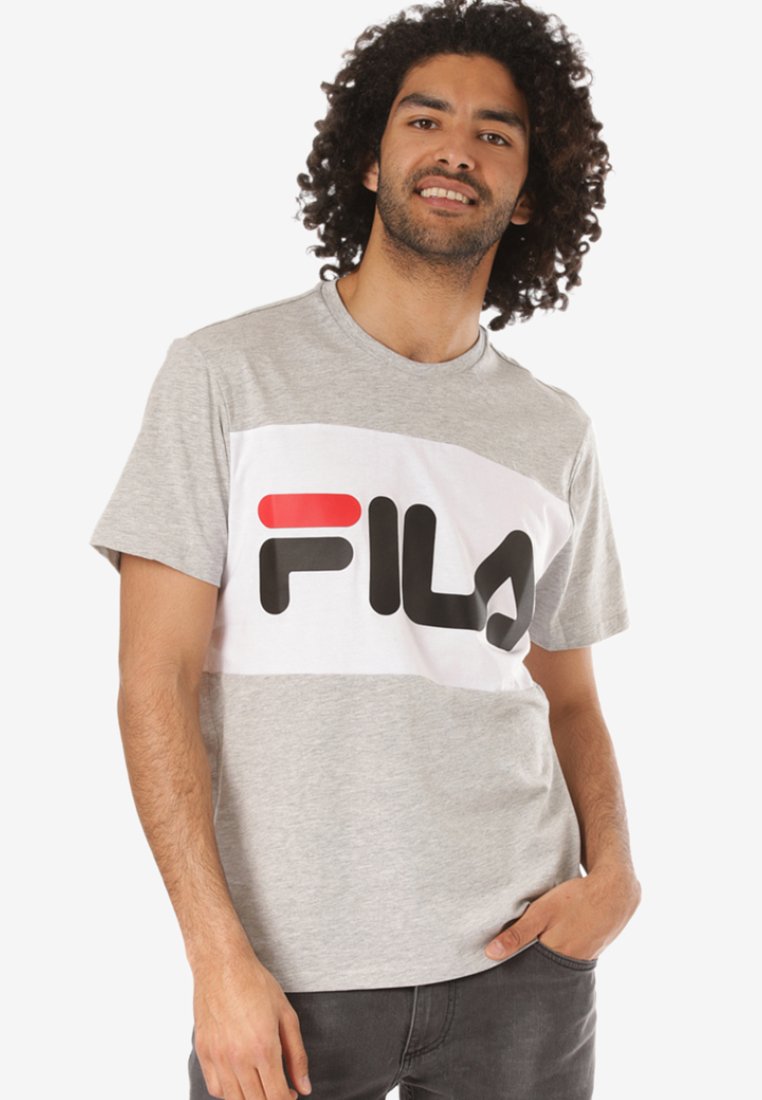 Pilkos spalvos trumpas rankovėmis marškinėliai su balta horizontalia juostele, kurioje ryškiai juodas "FILA" logotipas ir raudonas akcentas. Minkšta medžiaga, laisvas siluetas.