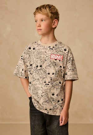 Beige kortærmet t-shirt med sorte stregtegninger af Marvel-figurer og et rødt "MARVEL" logo-badge på brystet.