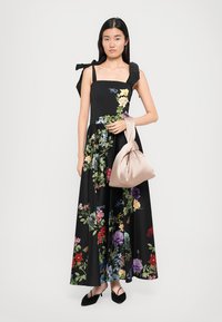 Maxime dress in musta kangas, jossa on värikäs kukkakuosi, neliön muotoinen pääntie ja suuret olkakannet. Yhdistetty pehmeään beigeen käsilaukkuun.