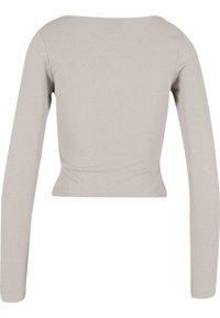 Lys grå langermet topp laget av teksturert stoff med en liten skimmer. Figursydd design med firkantet halslinje og strukturert silhuett.
