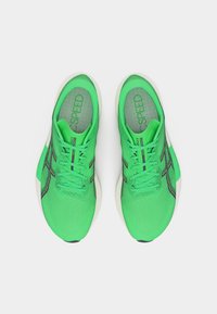 Ζευγάρι φωσφορίζοντα πράσινα παπούτσια τρεξίματος Asics με μαύρες λεπτομέρειες, λευκές ενδιάμεσες σόλες και το κείμενο "MAX SPEED" τυπωμένο στις εσωτερικές σόλες.