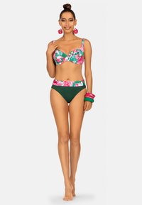 Dwuczęściowy bikini z kwiatowym wzorem na górze w kolorach różowym i zielonym oraz gładkim zielonym dołem. Do kompletu dobrane akcesoria.