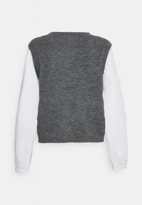 Grijze gebreide trui met een cropped ontwerp, voorzien van witte lange mouwen. Zachte textuur met een ronde halslijn en geribde randen.