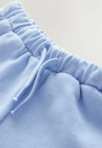Lyseblå bomulds sweatschorts med elastisk talje og snor, der har en glat overflade og indsamlet stofdetalje.