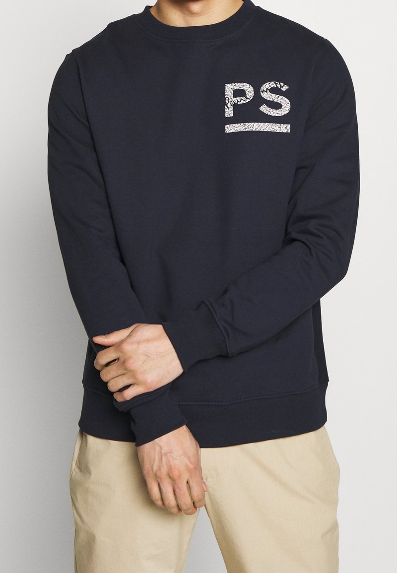 Sudadera azul marino de mezcla de algodón, con cuello redondo, mangas largas y un logo "PS" blanco con diseño en el pecho.
