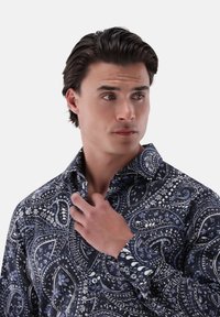 Dunkelblauses langärmliges Hemd mit einem Paisleymuster in Weiß und Hellblau, ausgestattet mit einem klassischen Kragen und einer durchgehenden Knopfleiste.