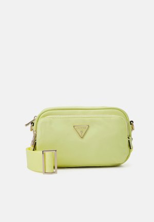 Sac bandoulière rectangulaire vert clair avec poche avant zippée, sangle ajustable et plaque logo Guess dorée.