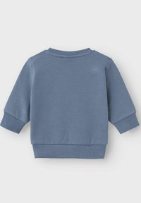 Felpa blu realizzata in morbido cotone. Caratterizzata da un colletto rotondo, spalle scese e polsini a coste. Design semplice e di un solo colore.