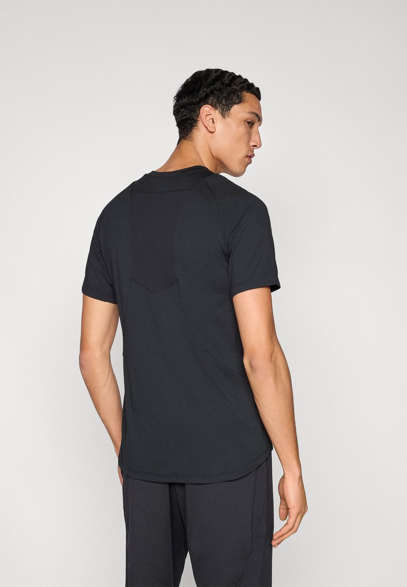 Black athletic t-shirt with short sleeves, rounded neckline, and textured back panel. Fabric appears lightweight and moisture-wicking.