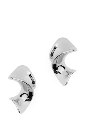 Paire de boucles d'oreilles en métal torsadé argenté brillant avec un design lisse, abstrait et courbé sur fond blanc.