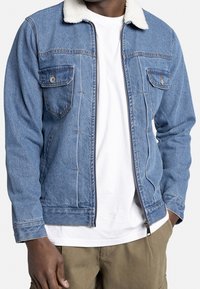 Denim jacket met een witte fleece kraag, voorzien van twee voorzakken, een ritsluiting en een lichtblauwe kleur met contrasterende stiksels.